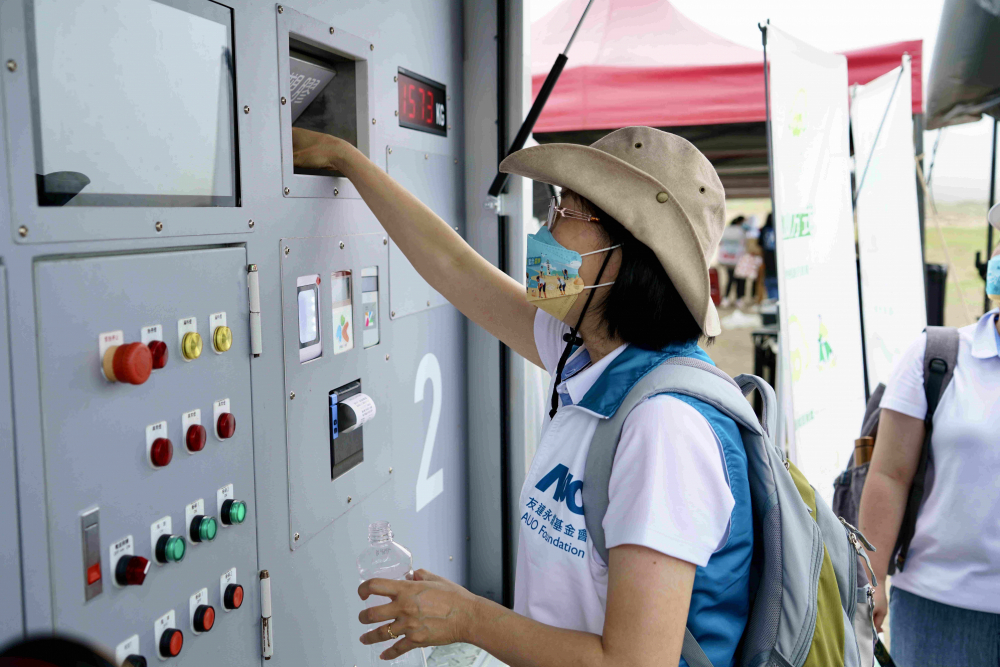 志工們將拾起的寶特瓶投入「好歸塑專車」，讓廢棄塑料空瓶可以直接粉碎、縮小體積，未來將可再製成購物袋、寶特衣、悠遊卡等生活用品